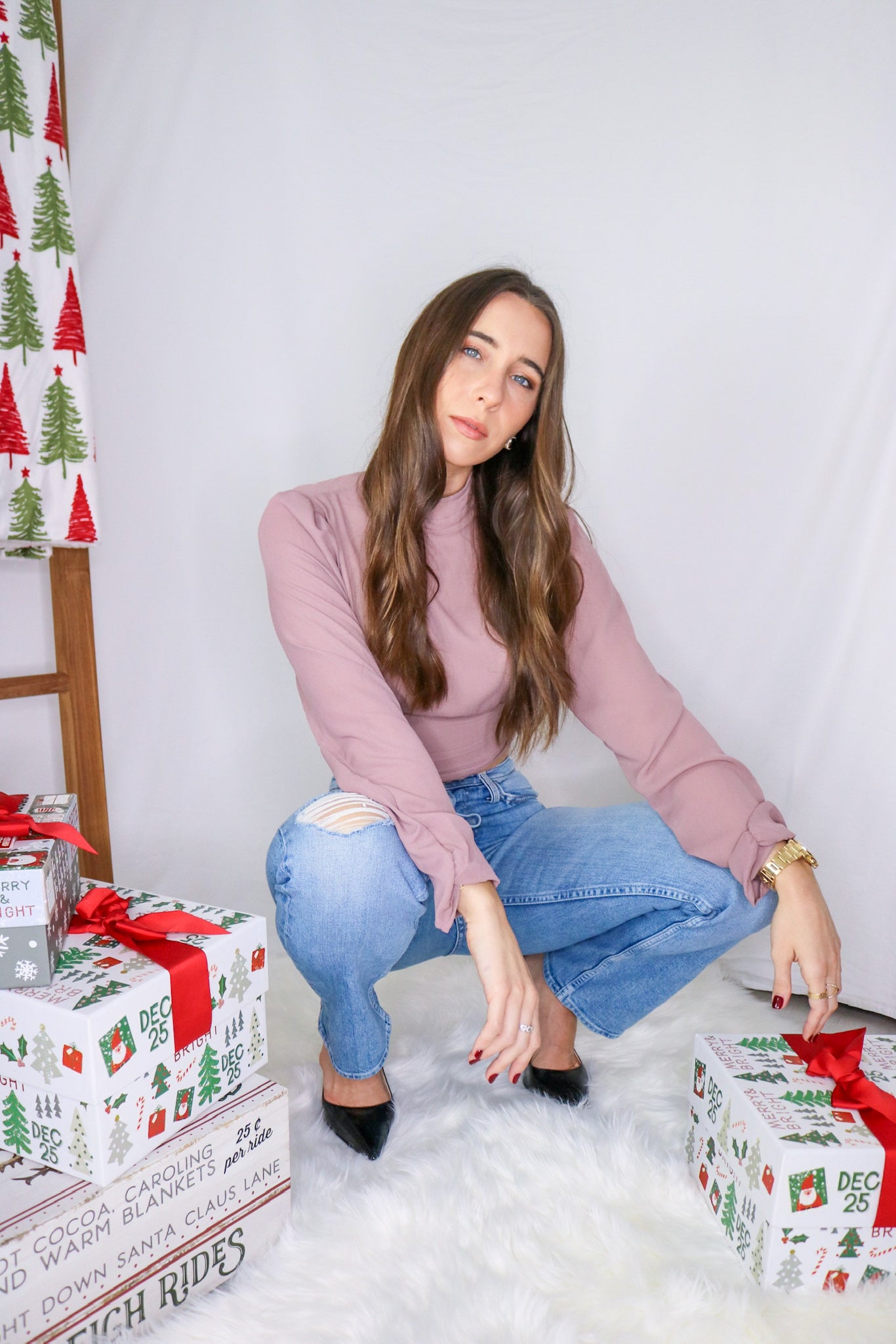 Brunette girl models high neck open back blouse in mauve for Scarlette The Label, an online fashion boutique for women. Paired with blue light wash denim jeans.